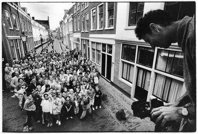 351067 Afbeelding van fotograaf Wim Mes die een groepsfoto maakt van de bewoners van de Springhaverbuurt op de ...